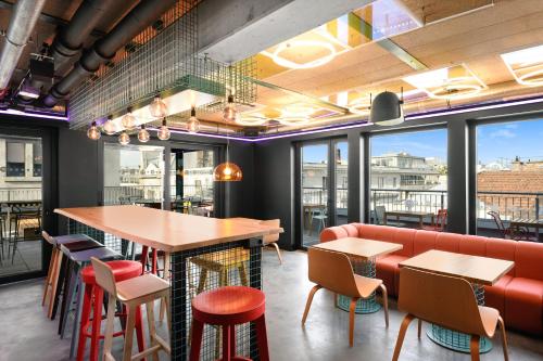 a restaurant with a bar and tables and chairs at JO&JOE Budapest in Budapest