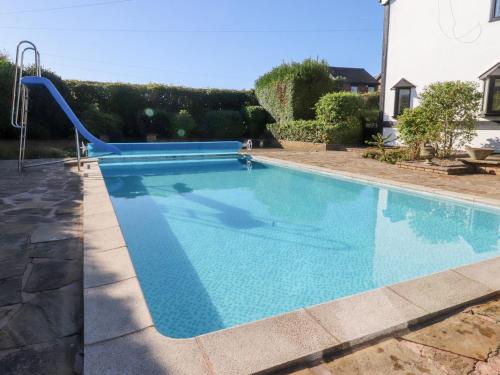 a swimming pool with a slide in a yard at Mayfield Cottage in Blackpool