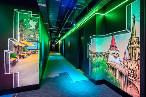a hallway with green and purple walls and paintings on the walls at JO&JOE Budapest in Budapest