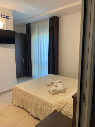a hotel room with a bed with towels on it at Hotel Ulisse in Marina Romea