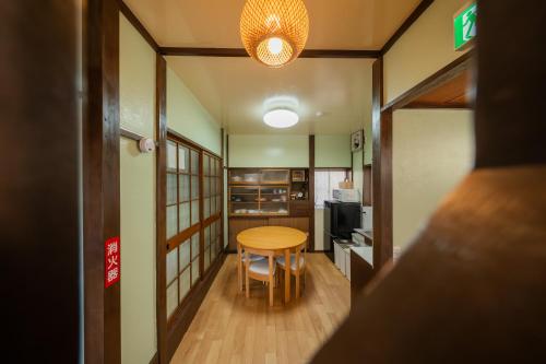a small room with a table and a kitchen at 日本の生活を体験できる古民家 一棟貸切最大7名 jr上中里駅 in Tokyo
