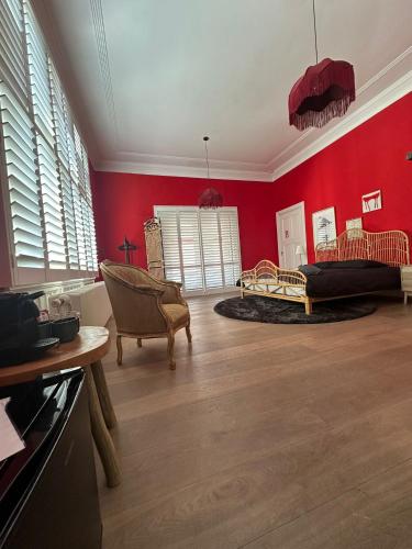 a living room with red walls and a couch at Romantic Rouge Suite - With Round Bath in The Hague