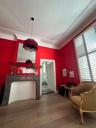 a living room with red walls and a fireplace at Romantic Rouge Suite - With Round Bath in The Hague