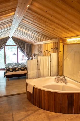 a large bath tub in a room with a bed at Chalet-Hôtel La Chemenaz in Les Contamines-Montjoie
