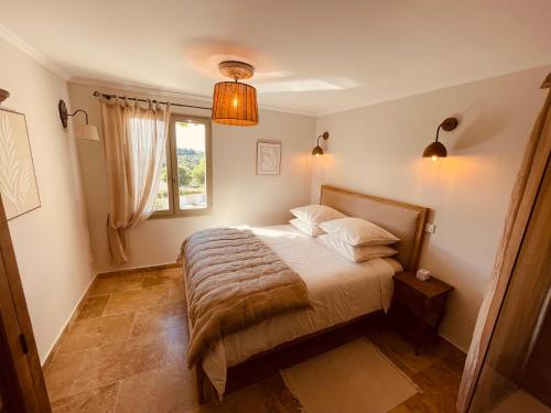 a bedroom with a bed and a window at La Réserve Provence in Vaugines