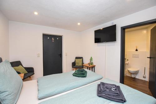 a hotel room with two beds and a bathroom at Haus an der Ache in Fieberbrunn