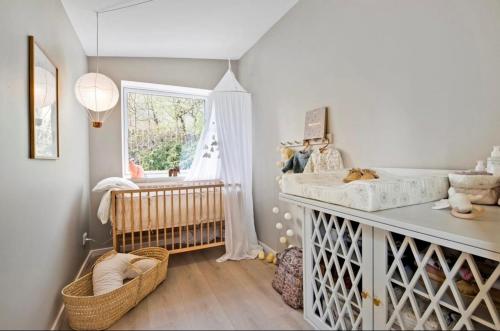 a baby room with a crib and a sink at Exclusive First Floor with Designer Touches in Kongens Lyngby