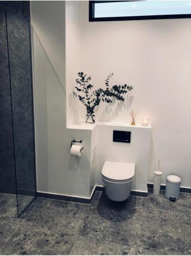 a bathroom with a toilet with a plant on the wall at Exclusive First Floor with Designer Touches in Kongens Lyngby