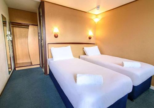 two beds in a hotel room with white sheets at The Runmere Hotel, Part of AG Collection in Runcorn