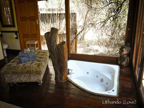 una vasca da bagno in una stanza con una finestra di Ihlozi Bush Lodge a Hluhluwe