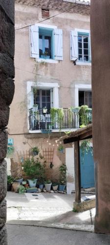 a building with windows and potted plants in front of it at La Vannière in Le Poujol-sur-Orb