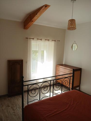 a bedroom with a bed and a window at La petite maison in Gourdon-en-quercy