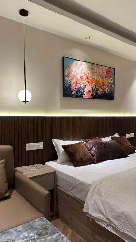a bedroom with a bed and a painting on the wall at Easy Stayz - Premium stays in Greater Noida in Greater Noida