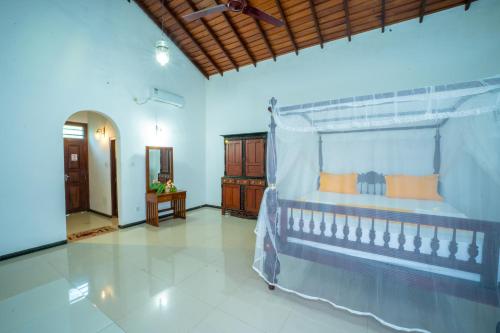 a bedroom with a canopy bed in a room at Araliya Gardens Hotel in Hikkaduwa