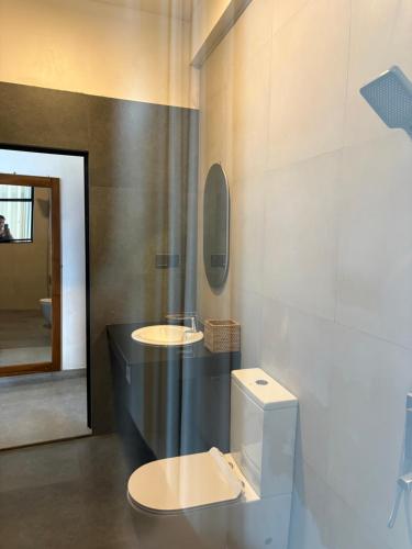 a bathroom with a toilet and two sinks in it at Reiss Villa Kandy in Kandy