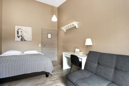 a bedroom with a bed and a desk and a chair at Reykjadalur Guesthouse in Hveragerði