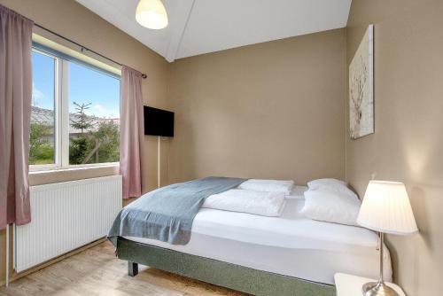 a bedroom with a bed and a large window at Reykjadalur Guesthouse in Hveragerði