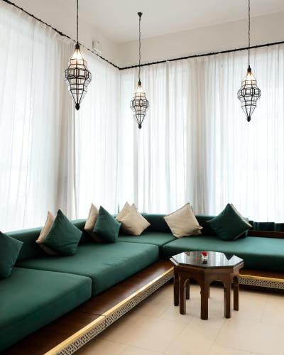 a living room with a green couch and a table at Banyan Tree Tamouda Bay in Fnidek