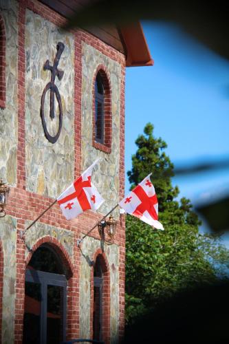 a building with a clock tower with flags on it at Iveria Parky and cottages in Shekvetili