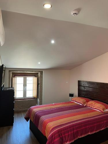 a bedroom with a large bed and a window at Casa da Saboaria in Almeida