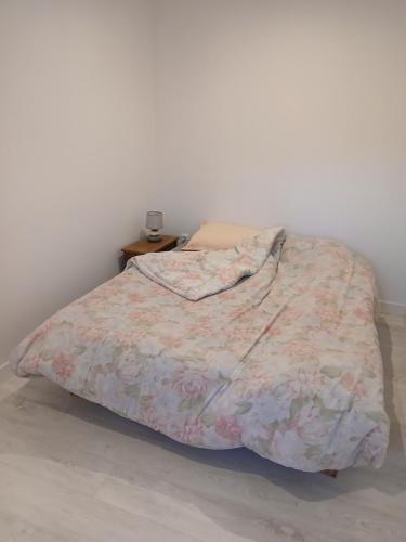 a bed with a blanket on it in a bedroom at La Rose des Vents 