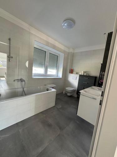 Un baño con bañera, inodoro y lavabo. en Gemütliche Doppelhaushälfte mit Garten, Terrasse Ruhige Lage in Hobersdorf, 