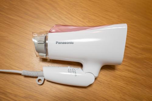 a white hair dryer and a hair brush on a table at 日本の生活を体験できる古民家 一棟貸切最大7名 jr上中里駅 in Tokyo