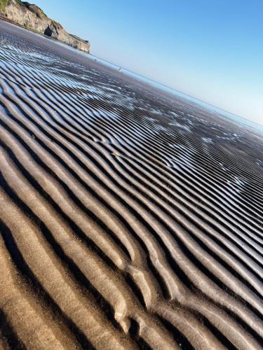 a sandy beach with ripples in the sand at Dune Cottage in Whitby