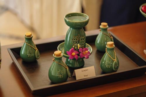 a group of green vases on a tray with a flower at Banyan Tree Tamouda Bay in Fnidek