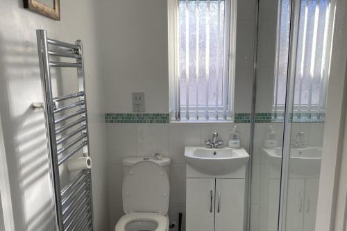une salle de bain blanche avec toilettes et lavabo dans l'établissement Cozy Dog Friendly cottage near Bridlington, à Bridlington