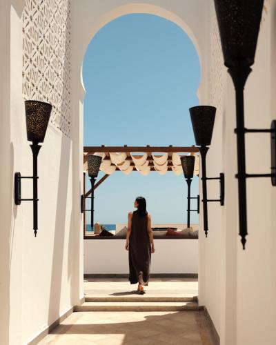 a woman walks through an archway in a building at Banyan Tree Tamouda Bay in Fnidek