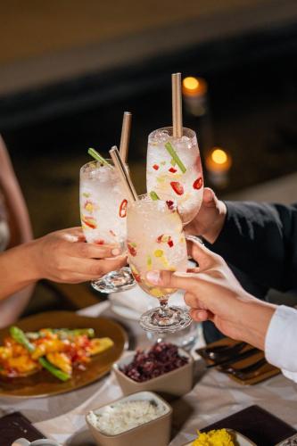 a group of people holding up glasses of food at Banyan Tree Tamouda Bay in Fnidek