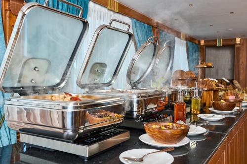 a kitchen with several trays of food on a counter at Shepherd I Dahabya in Esna
