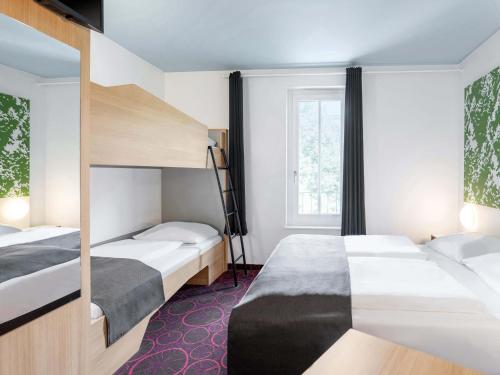 オッフェンブルクにあるB&B Hotel Offenburg-Cityのベッドが2つと窓があるホテルの部屋