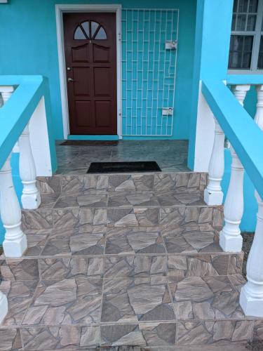 a front door of a blue house with a stone floor at Serene Blue Villa Hide Away in Non-Pariel