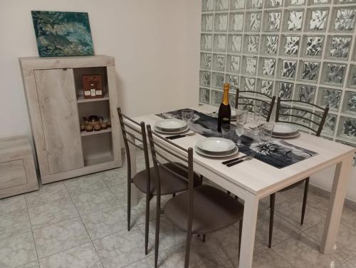 a dining room table with chairs and a bottle of wine at Almes' home in Bosisio Parini