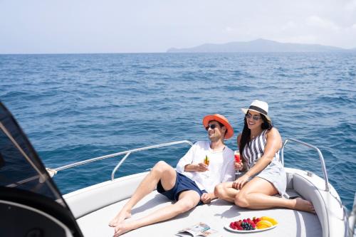 two people sitting on a boat in the water at Banyan Tree Tamouda Bay in Fnidek