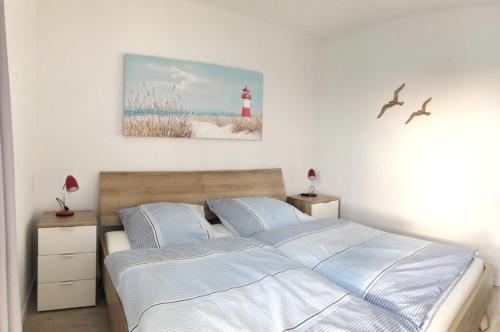 ein Schlafzimmer mit einem Bett und einem Leuchtturm an der Wand in der Unterkunft NordseeResort Friesland Ferienhäuser NordseeResort Friesland 48-6-n in Schillig