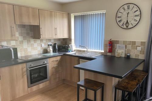 a kitchen with a large clock on the wall at Cozy Dog Friendly cottage near Bridlington in Bridlington