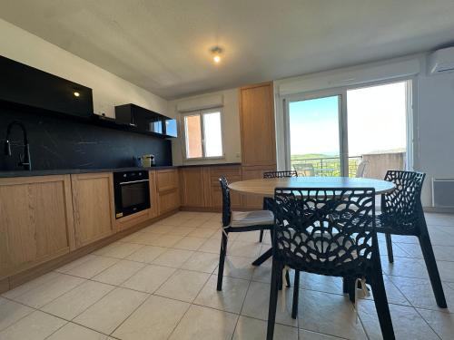 a kitchen with a table and two chairs and a table at Appartement Aurelia Vidauban in Vidauban
