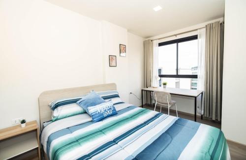 a bedroom with a bed and a desk and a window at Entire apartment in Kathu, Phuket, Thailand in Kathu