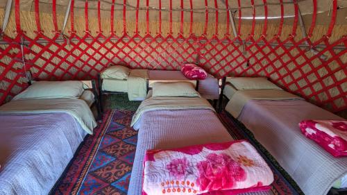 a group of beds in a red tent at Yurt camp KEREMET in Kyzart