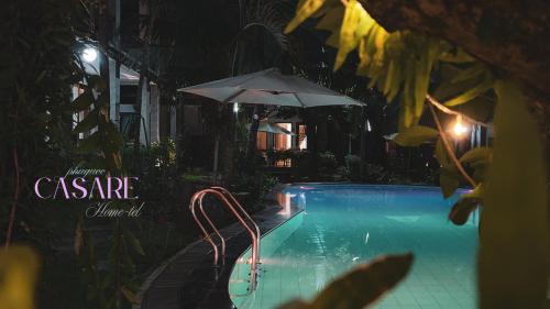 a swimming pool at night with an umbrella at Casare Phu Quoc - Formerly Caesar Hotel in Phu Quoc