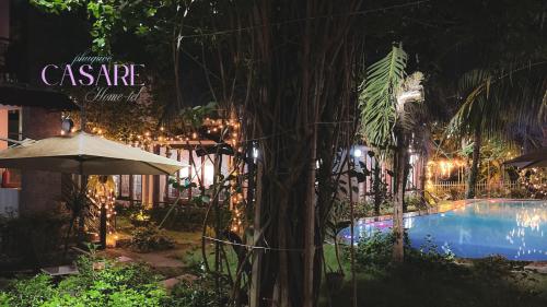 a swimming pool with an umbrella next to a building at Casare Phu Quoc - Formerly Caesar Hotel in Phu Quoc