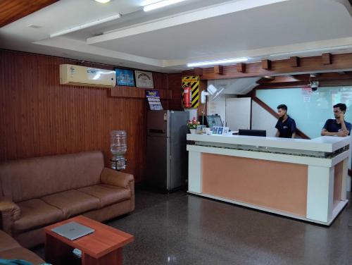 two people standing at a counter in a restaurant at Hotel O RKH Residency in Chennai