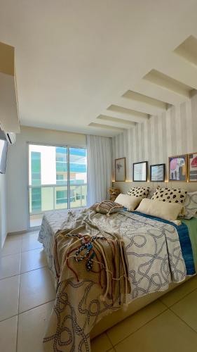 a bedroom with a large bed and a large window at Praia Grande Arraial do Cabo in Arraial do Cabo