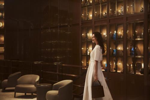 a woman in a white dress walking in a room at The St. Regis Istanbul in Istanbul