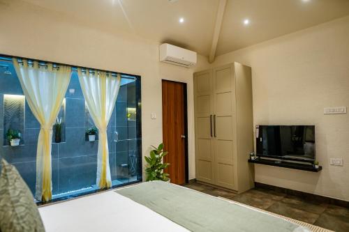 a bedroom with a bed and a tv and a window at Aeraki palms in Bordi