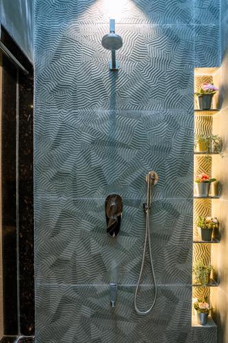a bathroom with a shower with a shower head at Aeraki palms in Bordi