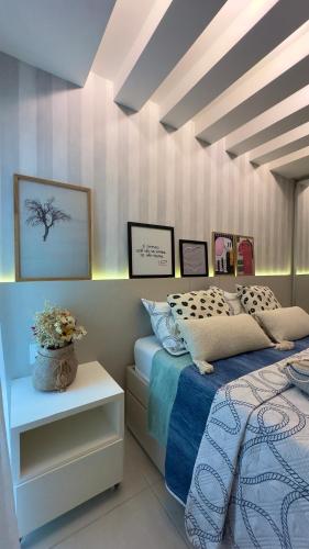 a bedroom with a bed and a vase of flowers on a table at Praia Grande Arraial do Cabo in Arraial do Cabo